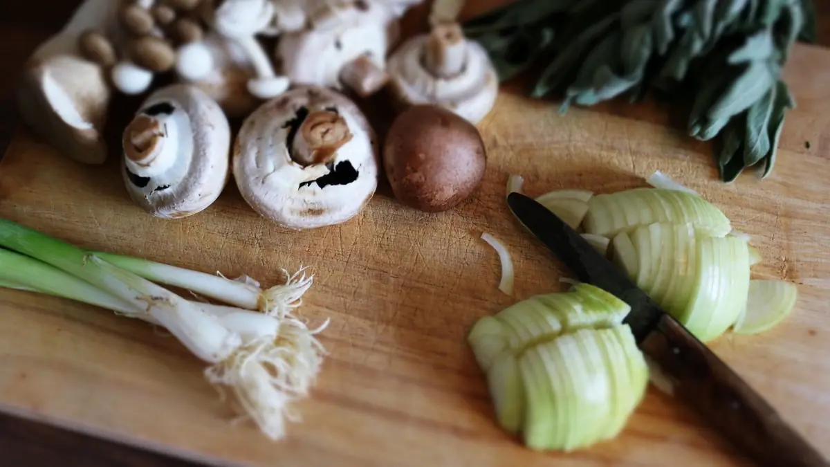 Verduras y un cuchillo sobre una tabla de madera