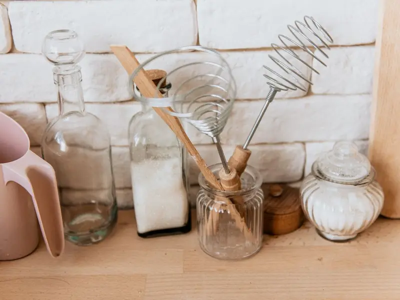 Tarros y botellas de vidrio con utensilios de madera