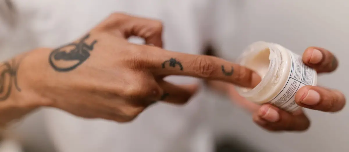 Mano cogiendo crema de un tarro